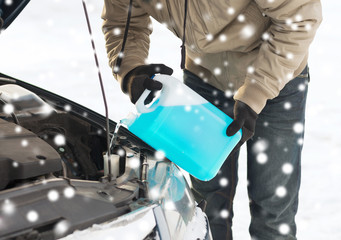 closeup of man pouring antifreeze into car