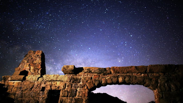  Astrophotography time lapse footage with tilt down motion of milky way galaxy rising over abandoned brick ruin structure at Knapp's Castle in Santa Barbala, California