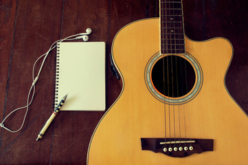 Fototapeta premium Notebook and wooden pencil on guitar