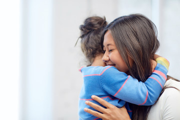 happy mother and daughter hugging at home