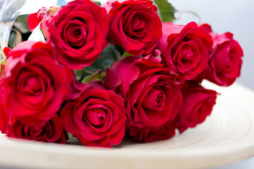 bouquet of red roses lying on a plate