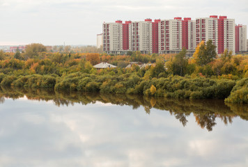 Residential apartments on a river bank in autumn 