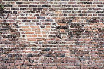 An old red wall made from bricks and rocks