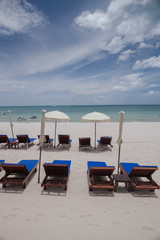 Beach on tropical island. Clear blue water, sand, clouds. 