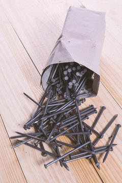 Pack full of nails on wooden table