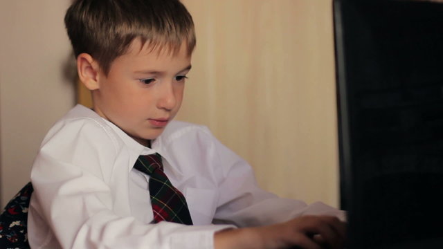 ittle boy schoolboy 8 years closeup in a white shirt and tie sat