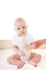 Baby eating with spoon.