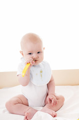Baby eating with spoon.