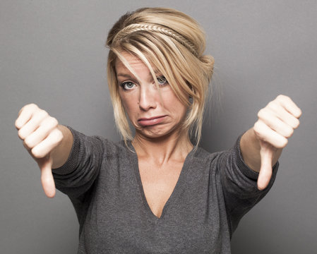 upset 20s girl expressing frustration with thumbs down