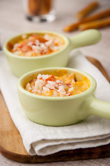 Cocotte with crab in the green ramekins on the wooden board
