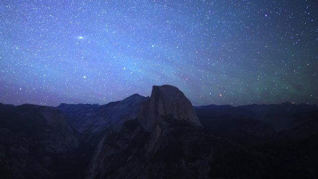 Time lapse footage of starry sky and low latitude aurora over Half Dome in Yosemite National Park, California