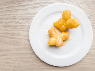 Top view of Chinese traditional Snacks deep fried doughstick on white plate with sweetened condensed milk.