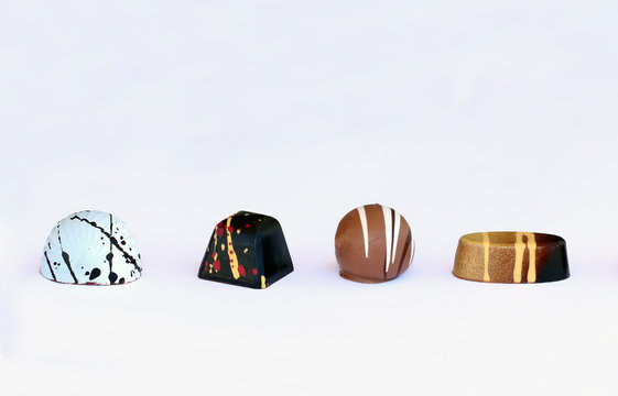 Four chocolate bonbons on white background