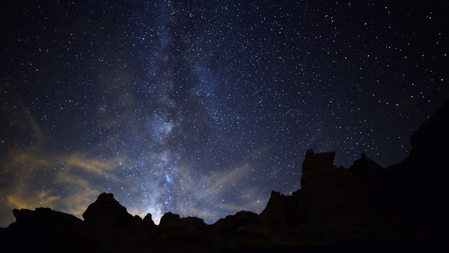 Astrophotography time lapse footage with zoom in motion of Milky Way galaxy spanning across rugged sandstone formation in Mojave Desert at Red Rock Canyon State Park, California
