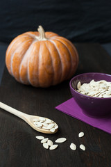 Bowl with toasted pumpkin seeds and wooden spoon