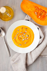 Pumpkin cream-soup with seeds in a white plate