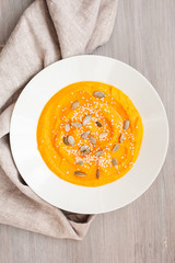 Pumpkin cream-soup with seeds in a white plate