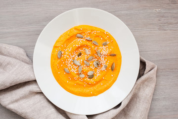 Pumpkin cream-soup with seeds in a white plate