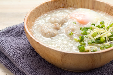Asian congee with minced pork and egg in white bowl.