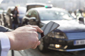 Man orders a taxi from his mobile phone. Close-up hands