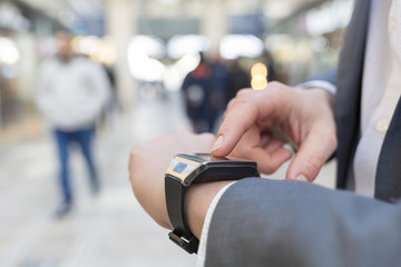 In hall station a man using his smartwatch. Close-up hands