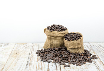 Fototapeta na wymiar Roasted coffee beans in a sack on a wooden background
