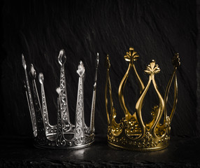 Two royal crowns with dark background