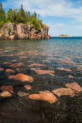 A scenic black sand and pink granite beach on the North Shore of