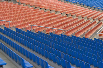 Obraz premium Rows of blue and orange plastic seats on stadium