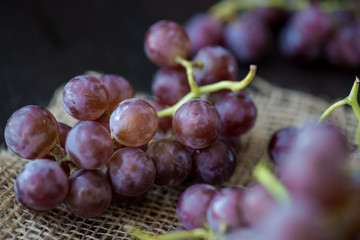 Bunch of grapes in the basket on wooden table