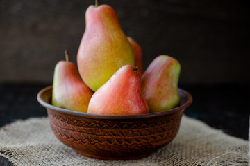 organic pears in the plate, on the wooden background