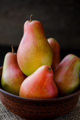 organic pears in the plate, on the wooden background
