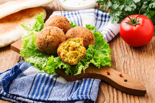 Chickpea falafel balls on a wooden desk with vegetables