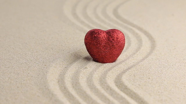 Red heart on a wavy sand, approximation
