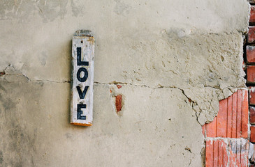 Love written on rustic brick wall. Grunge background. Love concept