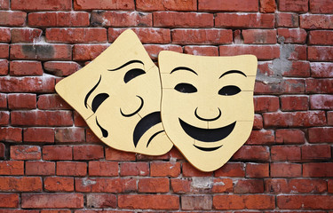Comedy and tragedy theater masks on old vintage brick wall