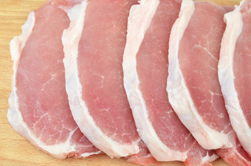 Raw meat steaks on wooden board background, DOF