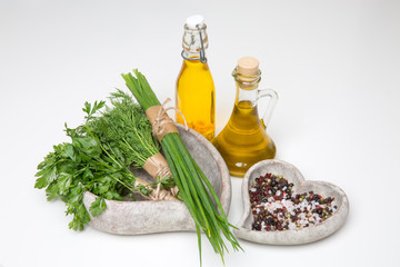 bunches of herbs, spices in a stone bowls and olive oil