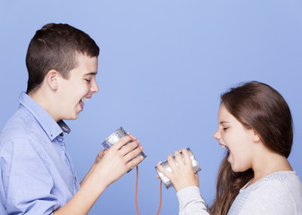Kids playing with a can as a telephone on blue background