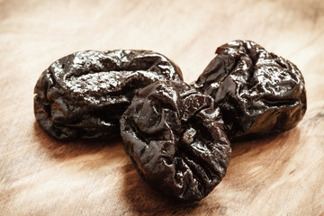 dried plums prunes on wooden table