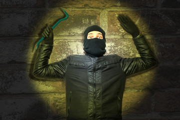 Light and masked theif with crowbar and balaclava gives up and keep hands up