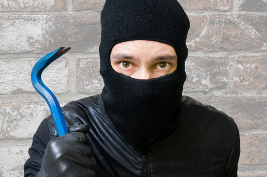 Face Of Masked Criminal Burglar That Holds Crowbar