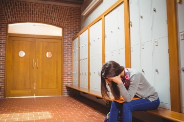 Worried student sitting in locker room