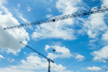 Crane at construction site white blue sky background