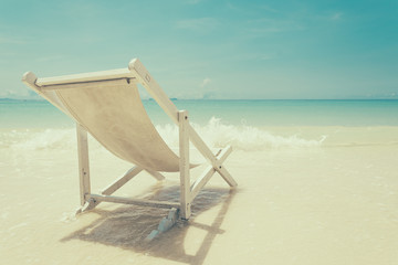beach chair on beach with blue sky - soft focus with film filter