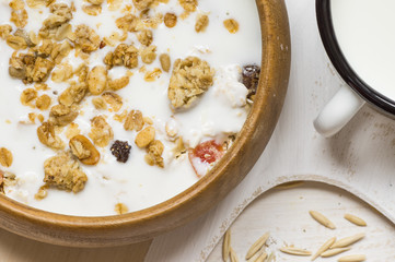 Muesli with milk in a rustic wooden bowl