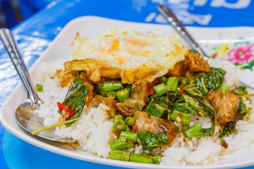 Steamed rice topped with stir-fried crisp pork , basil and over