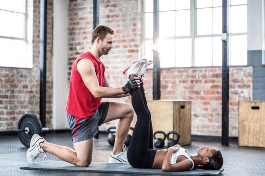 Muscular couple doing a leg stretching