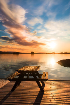 bench on a wooden pier at sunset