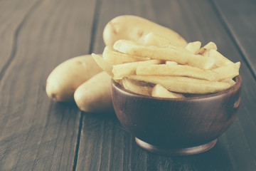 french fries on wood background - soft focus with vintage film f